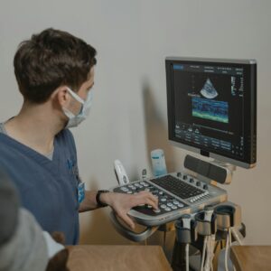 A veterinarian performing an ultrasound scan on an animal in a clinical setting.